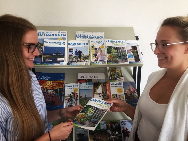 Von ausgelernter Azubine zu neuer Azubine: Sophia Wolfram (r.) zeigt ihrer neuen Kollegin Benita Santjer (l.) die Prospekte